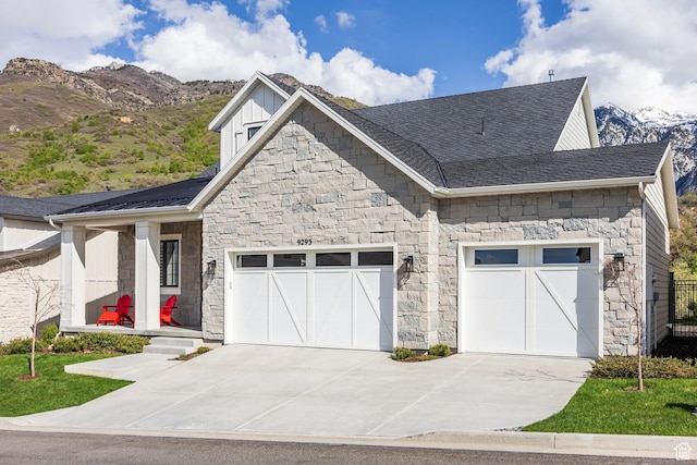 9293 S Regatta Ln, Cottonwood Heights, UT 84093 - view of front facade with board and batten siding, a mountain view, an attached garage, concrete driveway, and stone siding