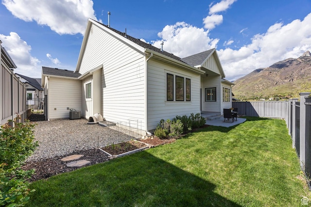 9293 S Regatta Ln, Cottonwood Heights, UT 84093 - back of property with a mountain view, central AC, a lawn, a fenced backyard, and a patio area