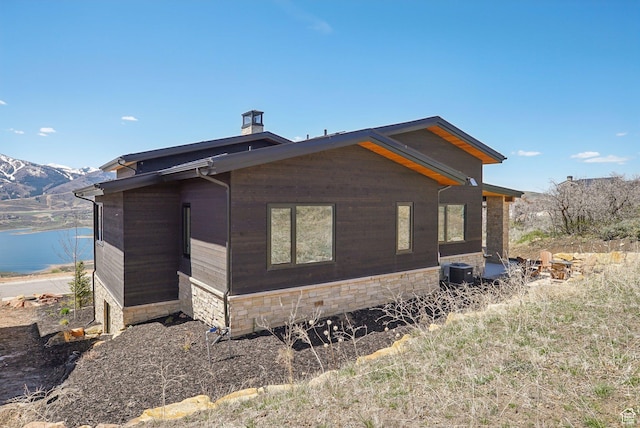 11332 N White Tail Ct Unit 30, Hideout, UT 84036 - view of side of home with central air condition unit, a water view, and a chimney