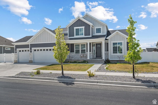 view of front facade featuring covered porch, board and batten siding, fence, and a garage
