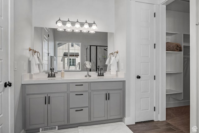 full bathroom featuring a shower stall, visible vents, a sink, and double vanity