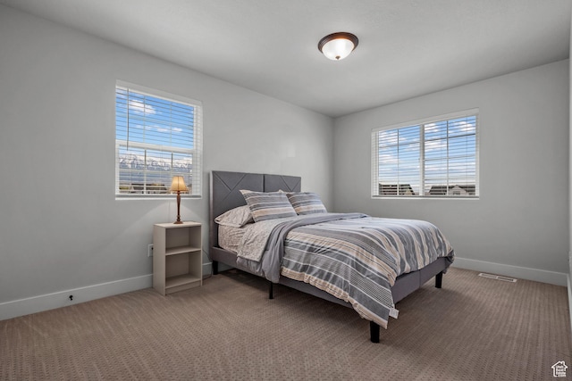 carpeted bedroom featuring visible vents and baseboards