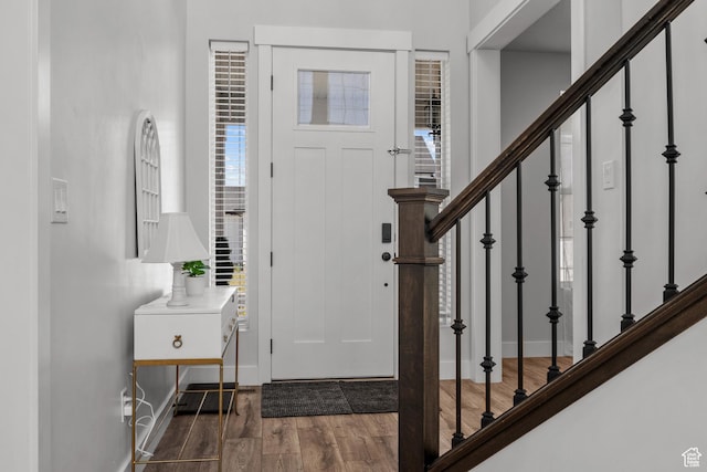 entryway with stairway, baseboards, and wood finished floors
