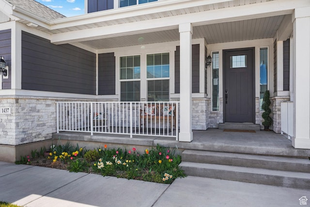 property entrance featuring a porch and stone siding