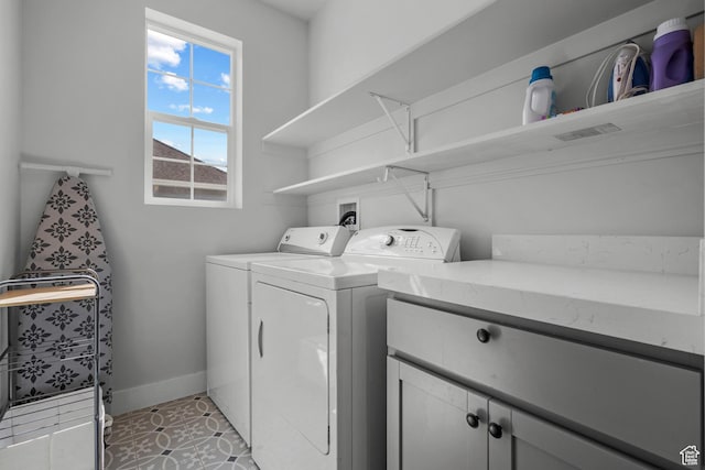 laundry area featuring cabinet space, independent washer and dryer, and baseboards