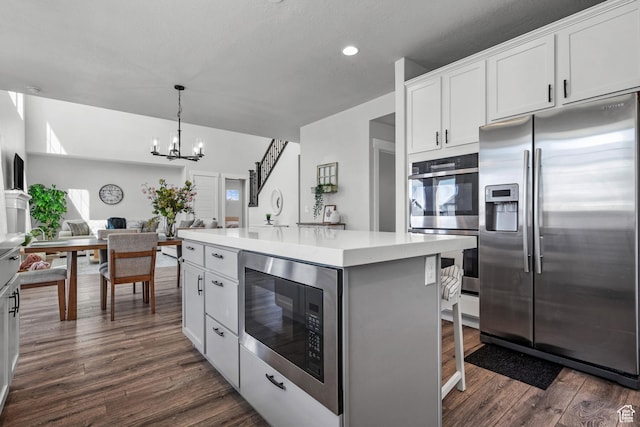 kitchen with recessed lighting, dark wood finished floors, a chandelier, light countertops, and appliances with stainless steel finishes