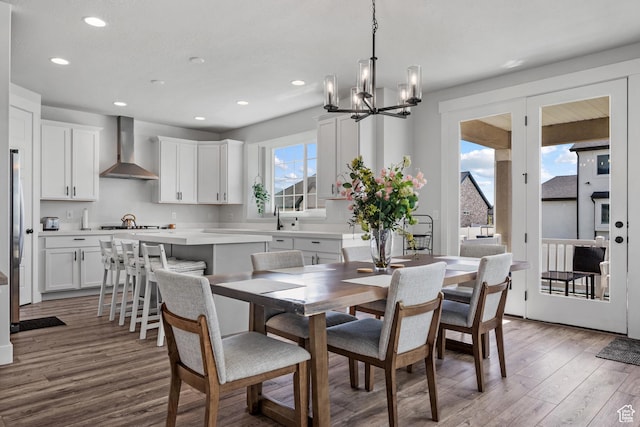 dining room with recessed lighting, light wood-type flooring, and a notable chandelier
