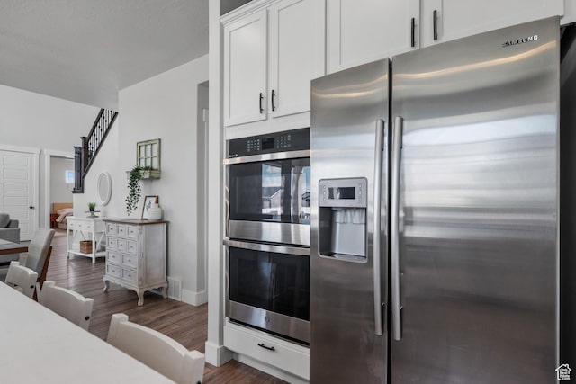 kitchen featuring white cabinetry, visible vents, dark wood-style flooring, light countertops, and appliances with stainless steel finishes