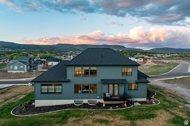 back of house featuring a mountain view and a shingled roof