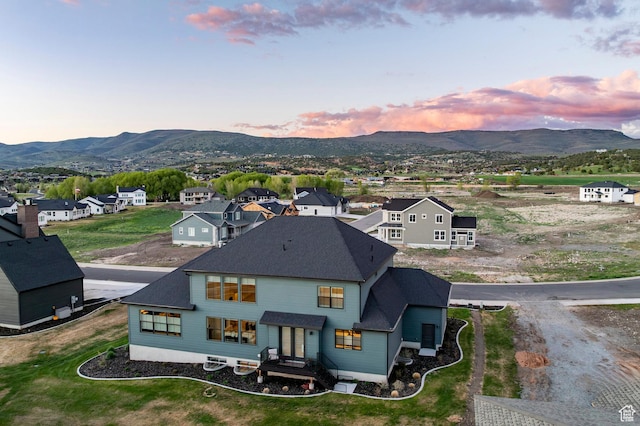 back of property featuring a mountain view, a residential view, and roof with shingles