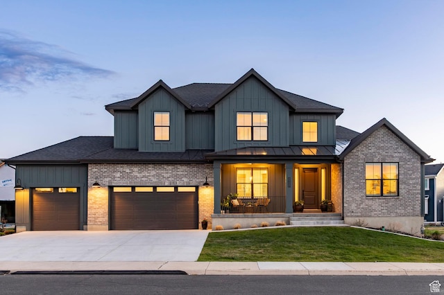 modern farmhouse featuring a porch, a yard, board and batten siding, and brick siding