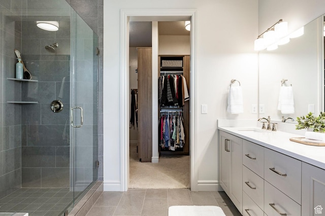 bathroom featuring a stall shower, vanity, tile patterned floors, and a spacious closet