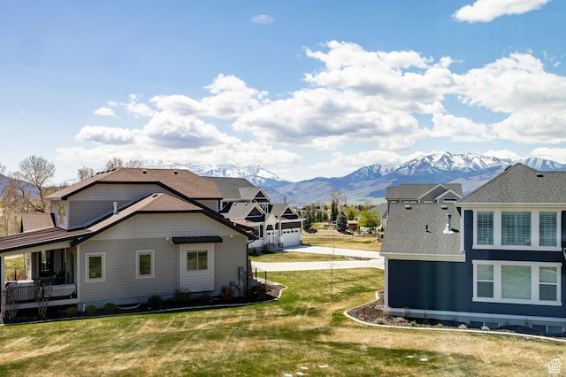 view of side of home with a mountain view and a lawn