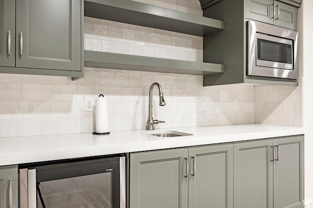 kitchen featuring open shelves, gray cabinets, beverage cooler, and stainless steel microwave