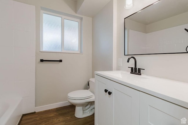bathroom with toilet, baseboards, wood finished floors, and vanity