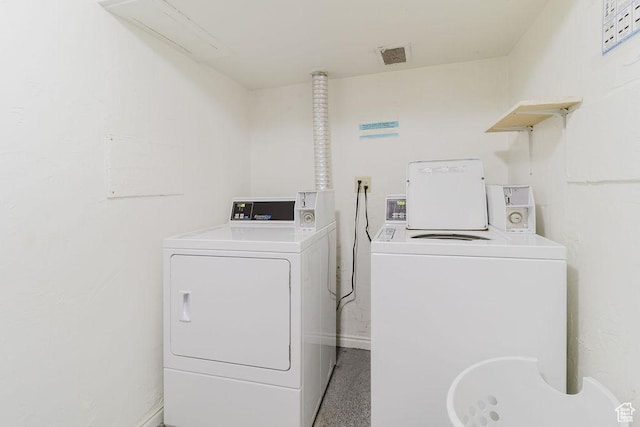 clothes washing area featuring washer and clothes dryer and visible vents