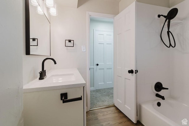 full bath with bathtub / shower combination, wood finished floors, and vanity