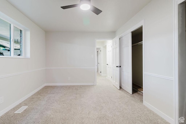 unfurnished bedroom with a ceiling fan, a closet, visible vents, baseboards, and light colored carpet