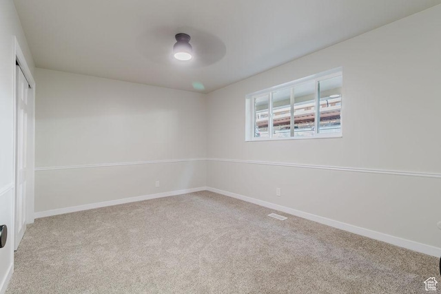 spare room featuring ceiling fan, carpet flooring, and baseboards