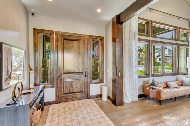 foyer entrance with baseboards, light wood finished floors, and recessed lighting