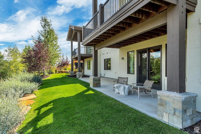 exterior space featuring a balcony, a yard, and a patio