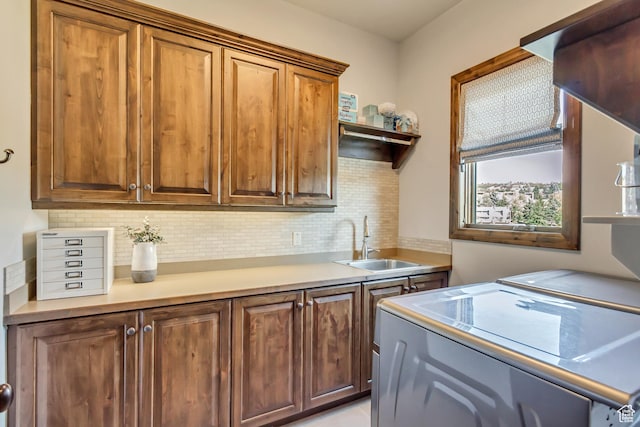 laundry area featuring washing machine and clothes dryer, cabinet space, and a sink