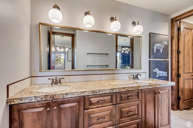 bathroom featuring a sink, an inviting chandelier, and double vanity