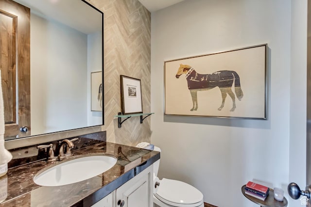 half bathroom featuring vanity and toilet