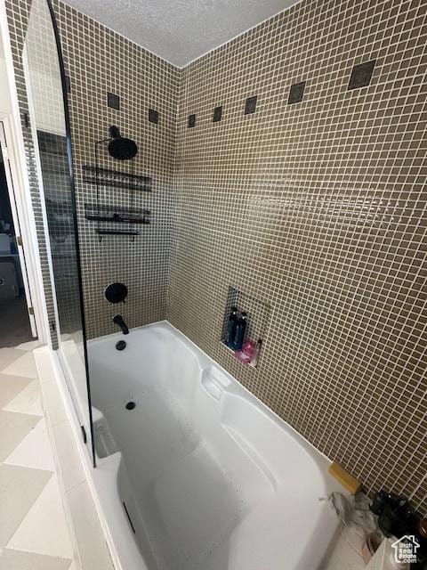 full bathroom featuring washtub / shower combination and a textured ceiling