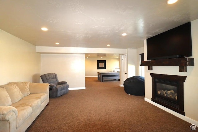 living area with baseboards, carpet flooring, a glass covered fireplace, and recessed lighting