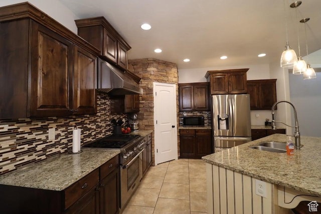 kitchen with a sink, stainless steel appliances, under cabinet range hood, backsplash, and light stone countertops