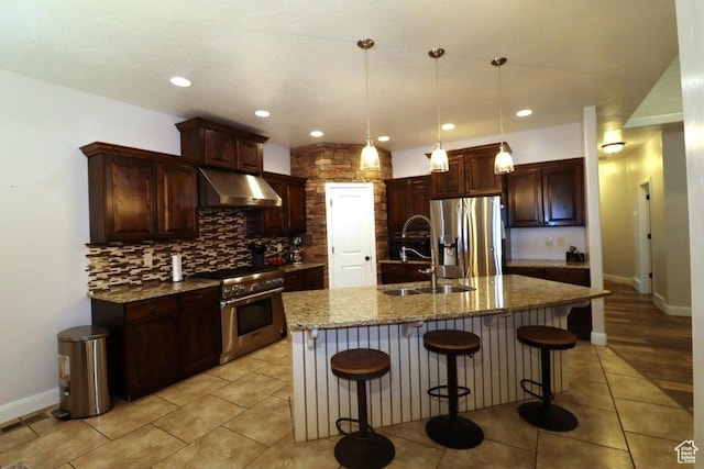 kitchen featuring light tile patterned floors, a sink, under cabinet range hood, appliances with stainless steel finishes, and tasteful backsplash