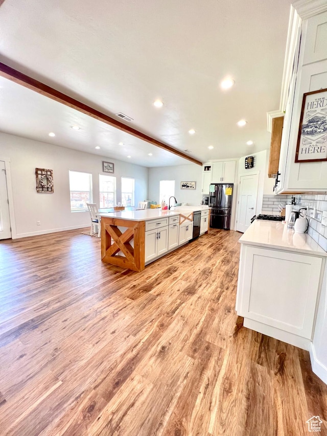 954 N 280 E, Elsinore, UT 84724 - kitchen with black dishwasher, a healthy amount of sunlight, light wood-style flooring, and stainless steel refrigerator with ice dispenser