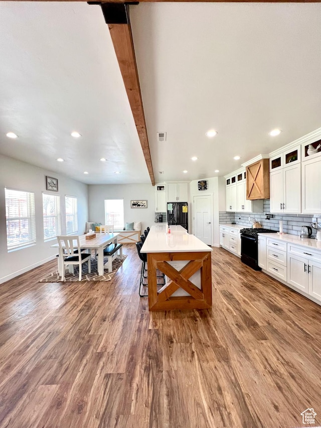 954 N 280 E, Elsinore, UT 84724 - kitchen with glass insert cabinets, wood finished floors, white cabinetry, black appliances, and decorative backsplash
