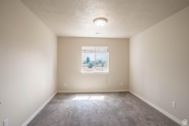 unfurnished room featuring baseboards, a textured ceiling, visible vents, and carpet