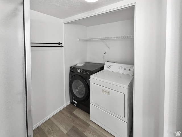 1303 N Riverside Ave Unit 32, Provo, UT 84604 - laundry area with light wood-style flooring, a textured ceiling, baseboards, washing machine and clothes dryer, and laundry area