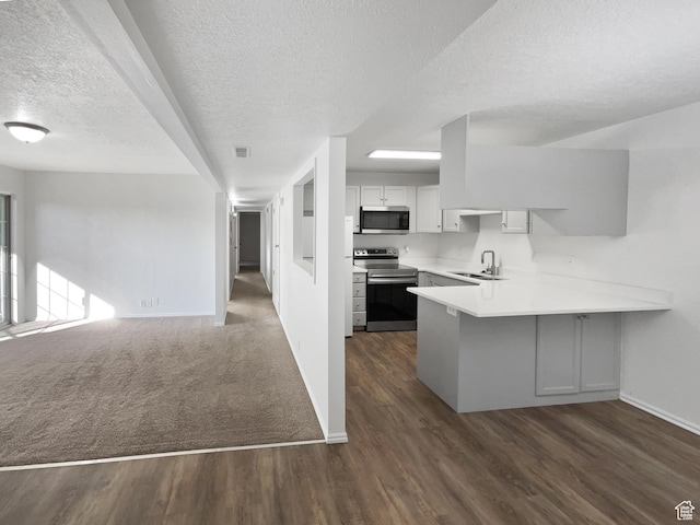 1303 N Riverside Ave Unit 32, Provo, UT 84604 - kitchen featuring a textured ceiling, baseboards, a peninsula, open floor plan, and appliances with stainless steel finishes