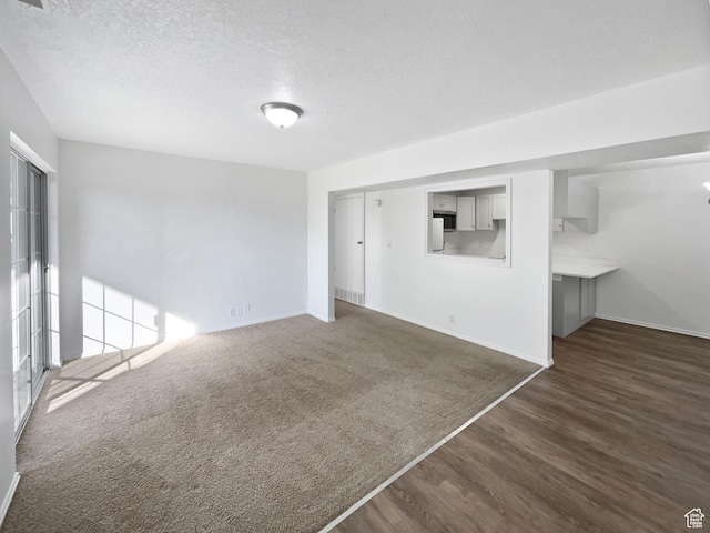 1303 N Riverside Ave Unit 32, Provo, UT 84604 - unfurnished living room featuring a textured ceiling, baseboards, and dark wood finished floors