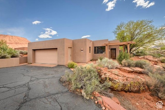 1151 W Shawnee Ct, Ivins, UT 84738 - pueblo-style home with stucco siding, aphalt driveway, and an attached garage
