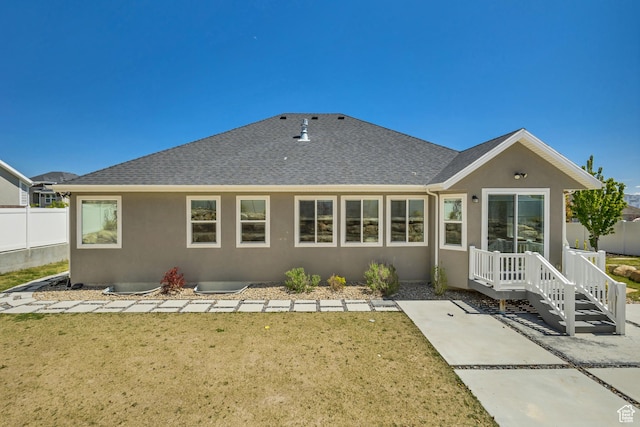 7518 S 5720 W, West Jordan, UT 84081 - back of property with stucco siding, roof with shingles, fence, and a lawn