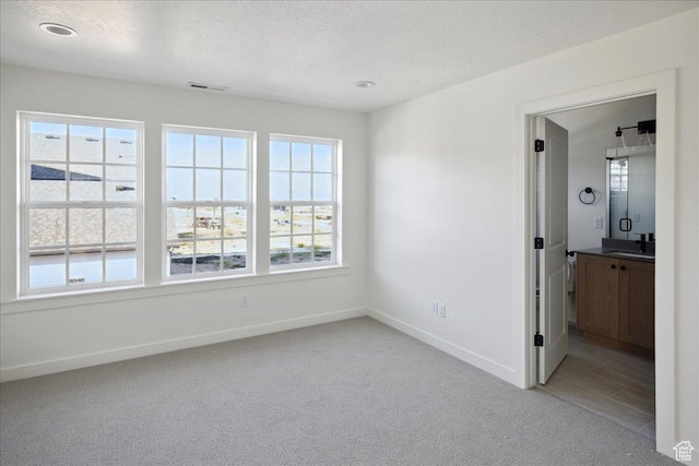 6768 W Docksider Dr Unit 298, South Jordan, UT 84009 - empty room featuring light carpet, baseboards, a textured ceiling, a sink, and recessed lighting