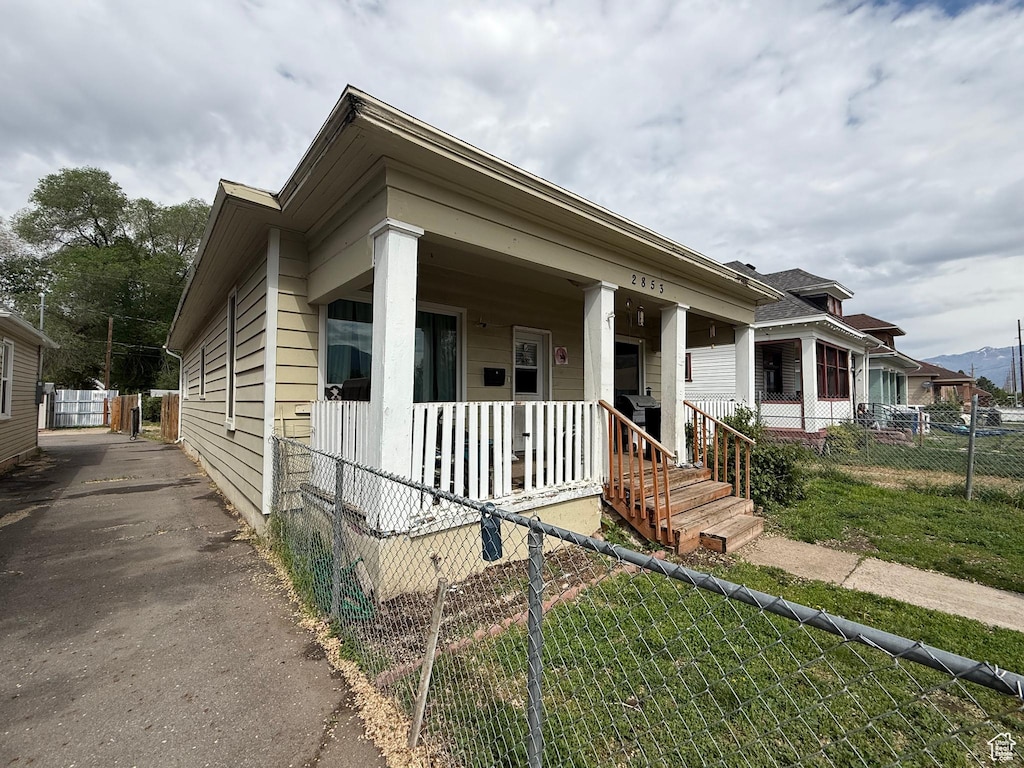 view of front of house with covered porch and fence