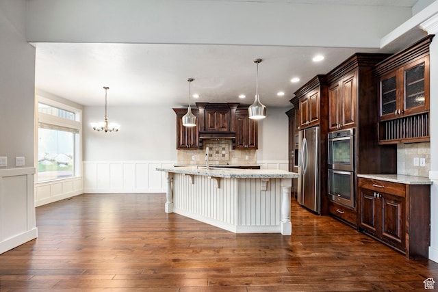 3440 Greenfield Cir, Mountain Green, UT 84050 - kitchen with a breakfast bar area, stainless steel appliances, dark wood-style flooring, wainscoting, and decorative backsplash