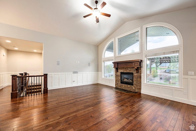 3440 Greenfield Cir, Mountain Green, UT 84050 - unfurnished living room featuring a wainscoted wall, dark wood-type flooring, a fireplace, and a ceiling fan