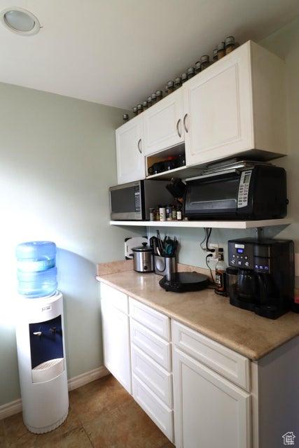 2304 S 11900 W, Cedar City, UT 84720 - kitchen featuring white cabinets, light countertops, baseboards, and black microwave