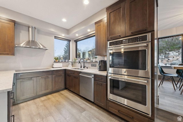 7515 Stagecoach Dr, Park City, UT 84098 - kitchen featuring appliances with stainless steel finishes, light wood-style flooring, wall chimney exhaust hood, and recessed lighting