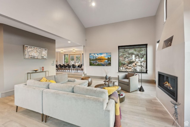 7515 Stagecoach Dr, Park City, UT 84098 - living room featuring high vaulted ceiling, a glass covered fireplace, light wood-style flooring, and recessed lighting