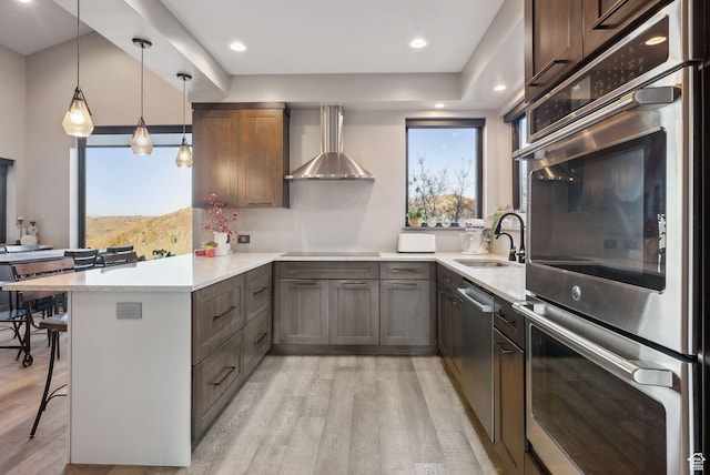 7515 Stagecoach Dr, Park City, UT 84098 - kitchen with appliances with stainless steel finishes, a peninsula, wall chimney range hood, and light wood-style floors