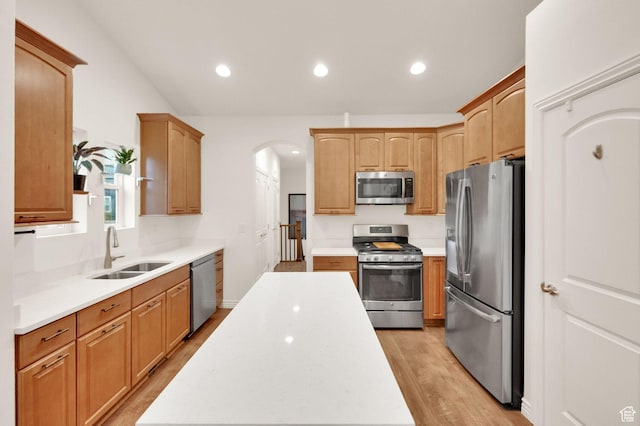 10557 S Pipestone Way S, Jordan, UT 84009 - kitchen with appliances with stainless steel finishes, a sink, arched walkways, light countertops, and light wood-type flooring