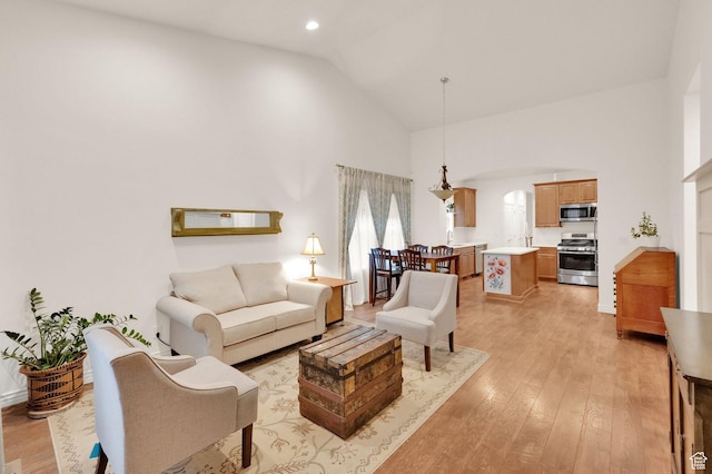 10557 S Pipestone Way S, Jordan, UT 84009 - living area with recessed lighting, light wood-style flooring, arched walkways, and high vaulted ceiling